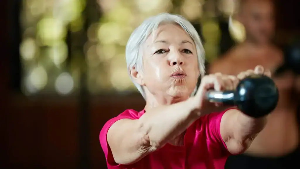 Older woman doing weight training Southend-on-Sea to help her strength and longevity 