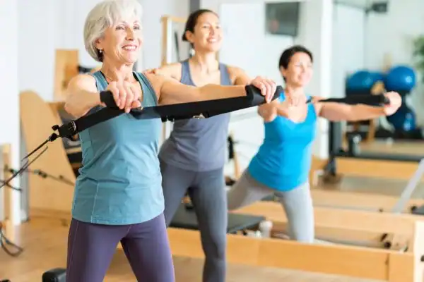 Toning Arms After 60: Empowering Womens Fitness Through Effective Weight Training 2 older woman doing weight training Southend-on-Sea and resistance in the gym to tone upper arms