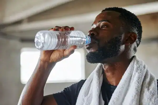Hydration: The Secret Ingredient for a Toned Stomach and Enhanced Fitness 1 Image of man drinking water to improve hydration Southend-on-Sea after work out.